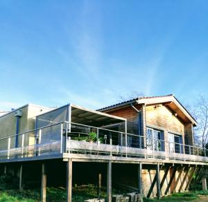 a house with a large deck on the side of it at Absolut Oiseaux in Parisot