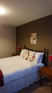 a bedroom with a bed with white sheets and pillows at Victoria Cloisters Apartments in York