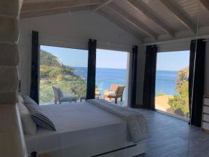 a bedroom with a bed and a view of the ocean at Rokamare in Liapades