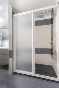 El baño incluye una puerta corredera de cristal con ducha. en B&B Porta delle Madonie, en Campofelice di Roccella