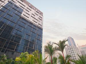 a tall building with palm trees in front of it at Capri by Fraser China Square, Singapore in Singapore