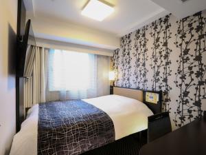 um quarto de hotel com uma cama e uma janela em APA Hotel Nihombashi Bakurocho Ekimae em Tóquio