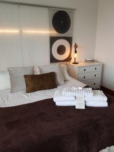 a bedroom with a bed with towels on it at Hôtel L'ideal le Mountbatten in Arromanches-les-Bains