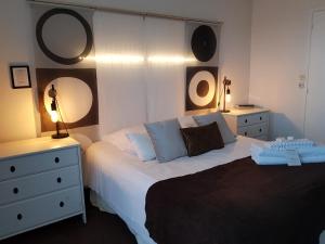 a bedroom with a bed with two dressers and two lamps at Hôtel L'ideal le Mountbatten in Arromanches-les-Bains
