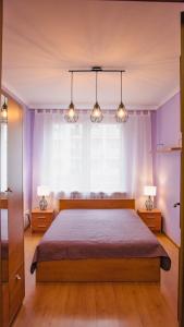 a bedroom with a bed with two lamps and a window at Mieszkanie przy Rynku in Racibórz