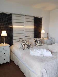 a bedroom with a large white bed with two night stands at Hôtel L'ideal le Mountbatten in Arromanches-les-Bains