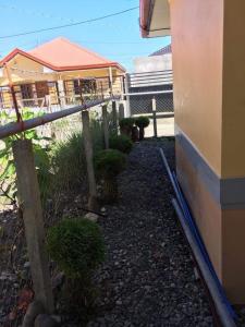 un jardín con plantas, una valla y un edificio en Jireh’s Guests Home, en Butuán