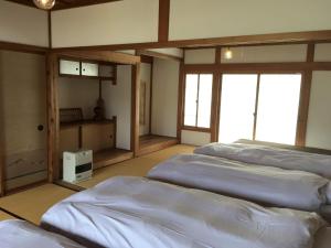 a room with three beds in a room with windows at KOME HOME in Tokamachi