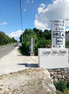 a sign on the side of a road at Mobile Homes Vila Punta in Šibuljina