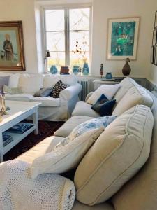 SandbyにあるLiv på Österlen Bed&Breakfastの白いソファとテーブルのあるリビングルーム