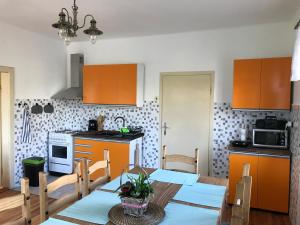 a kitchen with orange cabinets and a table and chairs at Rozboudovec in Křemže