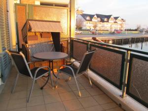 d'une table et de chaises sur un balcon avec vue sur la rivière. dans l'établissement Fewo Koje 22_OVER, à Karlshagen