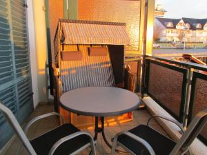 d'une petite table et de chaises sur un balcon. dans l'établissement Fewo Koje 22_OVER, à Karlshagen