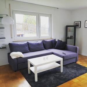 a living room with a purple couch and a white table at Ferien in Neuffen - Ferienwohnung Plaue in Neuffen