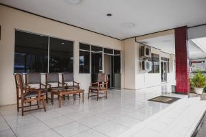 a dining room with chairs and a table and windows at RedDoorz @ Ungaran in Semarang