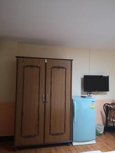 素攀府的住宿－Sab Suwarn Mansion，厨房配有木制橱柜和蓝色冰箱。