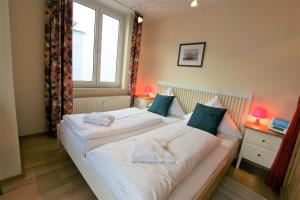 Cette chambre comprend un grand lit blanc et une fenêtre. dans l'établissement Villa Seeblick 208: Lichtdurchflutet mit Ostseeblick!, à Sassnitz