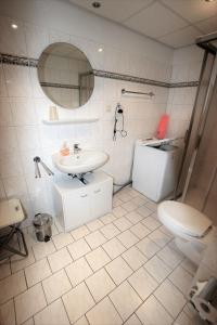 La salle de bains est pourvue d'un lavabo, de toilettes et d'un miroir. dans l'établissement Villa Seeblick 208: Lichtdurchflutet mit Ostseeblick!, à Sassnitz