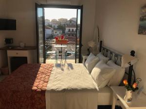 a bedroom with a bed with a view of a balcony at Ulysses Hotel in Methoni