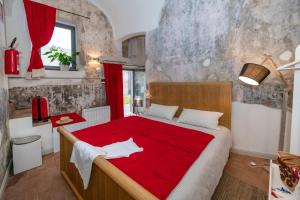 een slaapkamer met een groot bed en een rode deken bij Locanda La Fortezza in Finale Ligure