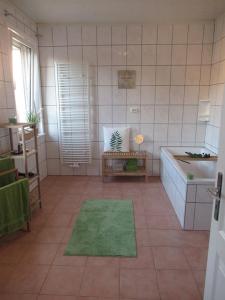 a bathroom with a tub and a green rug at Tolle Lage Hannover Braunschweig Wolfsburg in Leiferde
