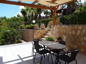 un tavolo e sedie su un patio con parete in pietra di Studios Rania - Rania Studios & Apartments a Lassi