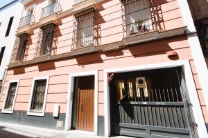 a pink building with windows and a door at El Refugio de San Luis con parking opcional in Seville
