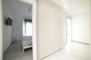 Biały korytarz z lustrem i łóżkiem w obiekcie SaMi B&B w mieście Scalea
