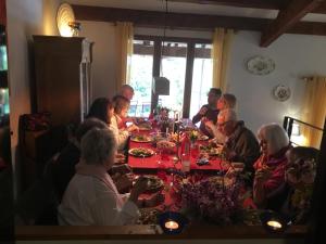 un grupo de personas sentadas alrededor de una mesa comiendo en Schwanenvilla, en Paraza