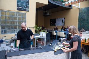 a man and a woman preparing food in a restaurant at Station - Hostel for Backpackers in Cologne +39 photos