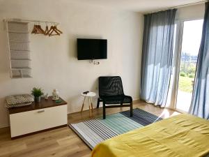 a bedroom with a bed and a chair and a tv at Apartments 57 in Portorož