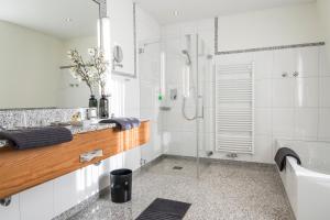 bagno bianco con doccia e lavandino di Landhaus Lellichow a Lellichow