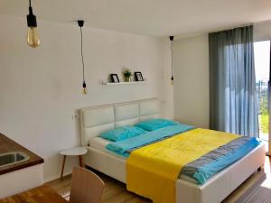 a bedroom with a bed with a yellow and blue blanket at Apartments 57 in Portorož