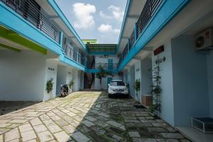 um carro estacionado no pátio de um edifício em RedDoorz @ Kartohardjo Madiun em Madiun