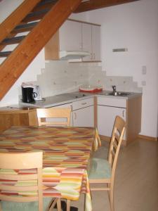 eine Küche mit einem Tisch und Stühlen im Zimmer in der Unterkunft Garni - Appartement Neumairhof in Oberrasen