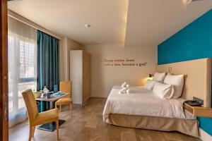 - une chambre avec un lit et une table avec une chaise dans l'établissement Ddream Hotel, à San Ġiljan