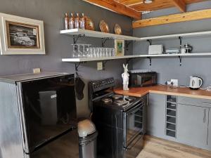 a small kitchen with a black stove and a counter at The Grey Plow in Clarens