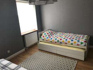 sypialnia z łóżkiem z kołdrą i oknem w obiekcie Apartament 'Laura' Tykocin w Tykocinie
