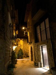 Figuerola de Orcau的住宿－Casa Tato Figuerola d'Orcau，夜间有空洞的小巷,有楼房