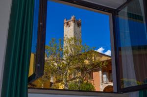 una ventana con vistas a un edificio y una torre en La Madrugada, en Malcesine