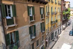 ヴェローナにあるDomus Verona - Accogliente residenza Rocchetto a 25mt da Piazza Erbeの通りに緑の襖が敷かれた古い建物