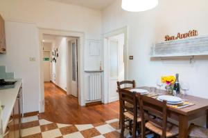 cocina y comedor con mesa y sillas en Domus Verona - Accogliente residenza Rocchetto a 25mt da Piazza Erbe, en Verona