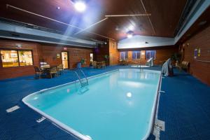a large hot tub in a room with tables and chairs at Miles City Hotel in Miles City