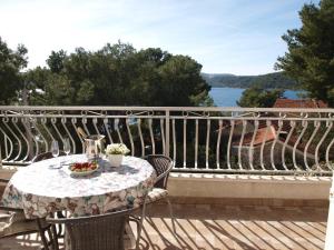 a table and chairs on a balcony with a view of the water at Villa Fendi in Nečujam