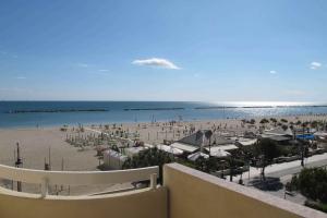 a view of a beach and the ocean from a balcony at Hotel Colorado Cesenatico in Cesenatico