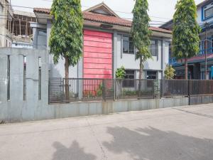 RedDoorz @ Buah Batu 3 في باندونغ: منزل فيه باب احمر على شارع