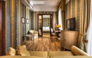 a living room with a couch and a television at Sina De La Ville in Milan