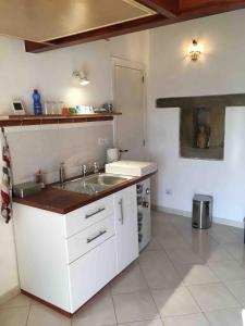 a white kitchen with a sink and a stove at Contrada Carmine in Reitano