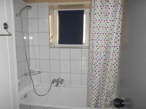 a bathroom with a tub and a shower curtain at Le Vieux Sart 3 in Stavelot