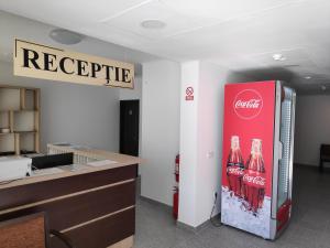 un frigorifero di cocacola in un ufficio con un cartello di Hostel Caliman a Caciulata